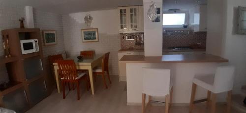 eine Küche und ein Esszimmer mit einem Tisch und Stühlen in der Unterkunft Casetta Iacono appartamento Aenaria in Ischia
