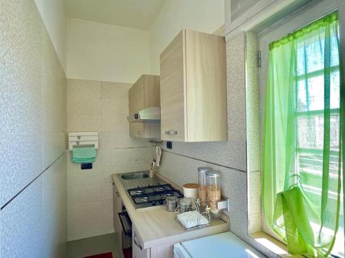 eine kleine Küche mit einem Herd und einem Fenster in der Unterkunft Tasso’s house in Neapel
