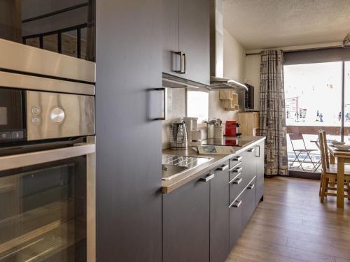 a kitchen with stainless steel appliances and a table at Apartment Apollo-2 by Interhome in Le Corbier