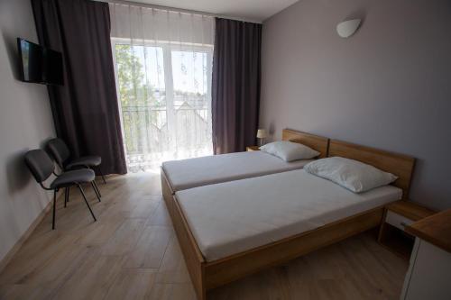 a bedroom with a bed and a large window at Planeta in Ustronie Morskie