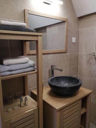 La salle de bains est pourvue d'un lavabo noir sur un comptoir en bois. dans l'établissement Domaine de Pech Mortier, à Marcillac-Saint-Quentin