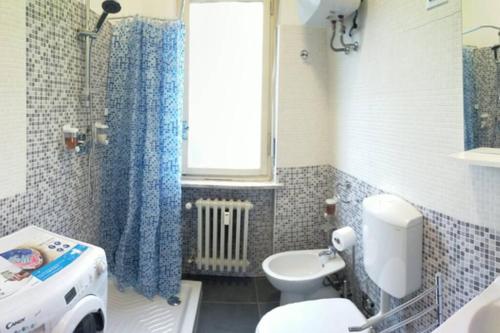 een badkamer met een wastafel, een toilet en een raam bij Locazione Turistica Casa Gardenia in Turijn