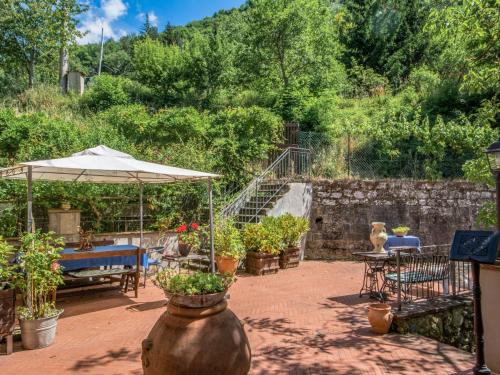 a patio with potted plants and an umbrella at Apartment Giallo by Interhome in Il Molinaccio