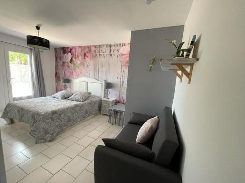 a bedroom with a bed and a couch and a chair at La Margottière chez isa et titi in Rians