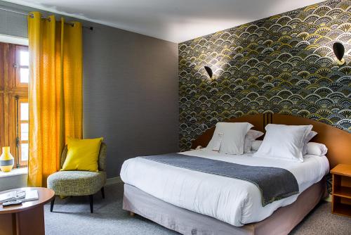 sypialnia z dużym łóżkiem i żółtą ścianą w obiekcie Hostellerie la Ferme du Poulet et son restaurant w mieście Villefranche-sur-Saône