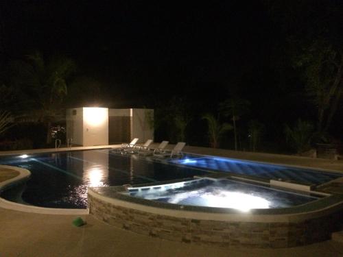 a swimming pool at night with chairs around it at Arizona Ranch Hotel in Girardot