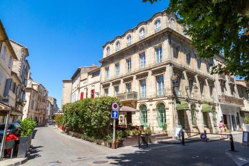 a large stone building on a city street at Hôtel Le Relais de Poste Arles Centre Historique in Arles