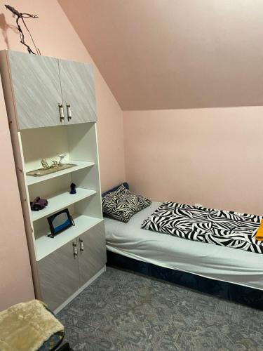 1 dormitorio con cama y estante para libros en Tóparti Vendégház - Lipót, Magyarország, en Lipót