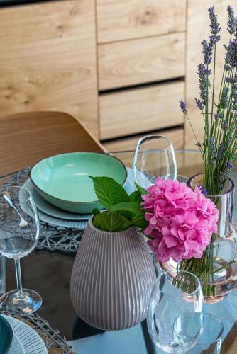 a table with a vase with purple flowers in it at Villa Luigi with a pool in Cavtat