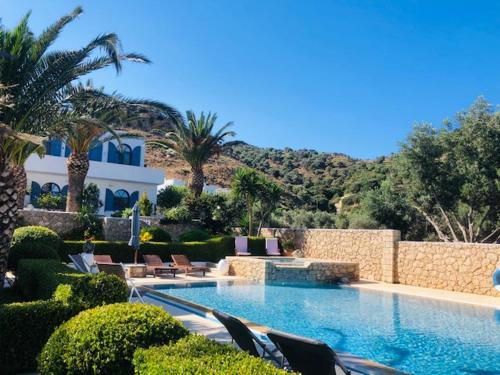 una piscina con sedie e alberi e un edificio di La Bastide a Skiros