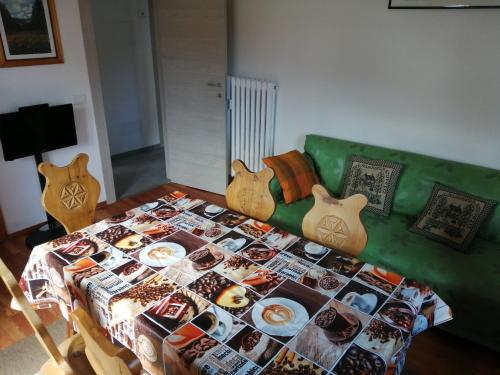 a green couch with a table with a blanket on it at Cervinia in Breuil-Cervinia