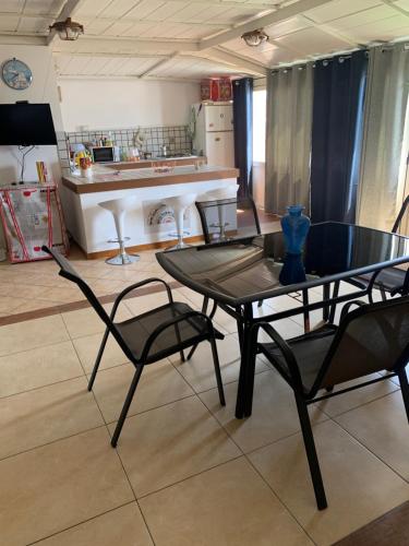 een eetkamer met een tafel en stoelen en een keuken bij Sealoft in Isola delle Femmine