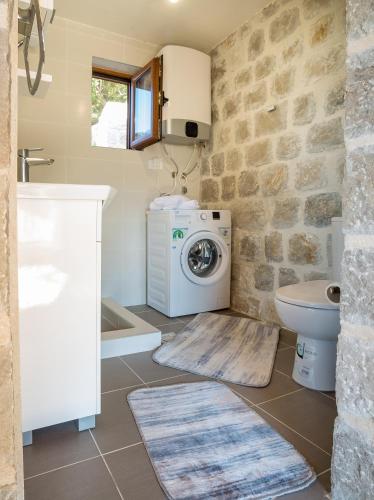 a bathroom with a washing machine and a toilet at VILLA MILENA in Kotor