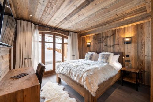 una camera con letto e soffitto in legno di Grand Pré a Val dʼIsère
