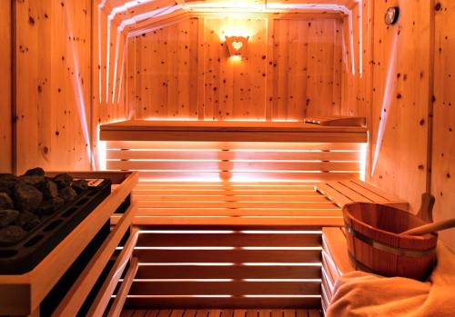 a sauna with a stove in a wooden wall at Florerhof Ferienwohnung Flieder in Vols am Schlern