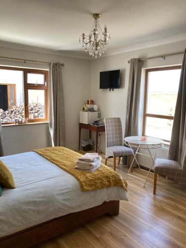 a bedroom with a bed and a table and chairs at Broadhaven Bay View Private House in Belmullet