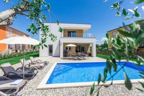 a villa with a swimming pool and a house at Holiday home Čančar by SeeAdria Agency in Fiorini