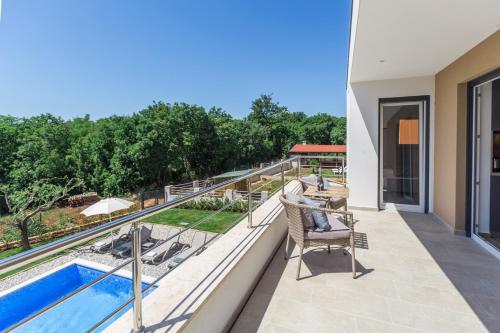 a balcony with a view of a pool and trees at Holiday home Čančar by SeeAdria Agency in Fiorini