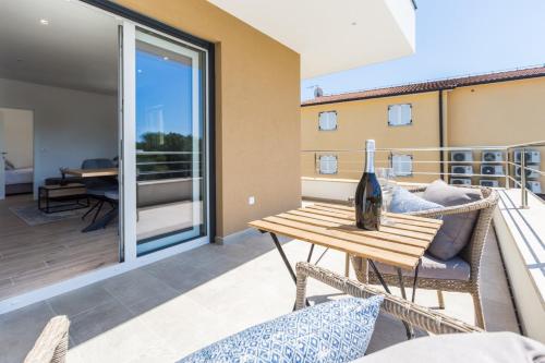 a balcony with a table with a bottle of wine on it at Holiday home Čančar by SeeAdria Agency in Fiorini