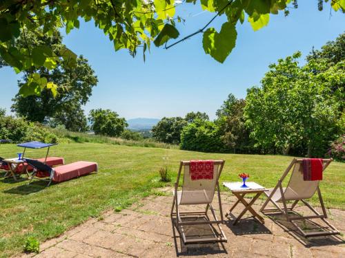 two chairs and a table in the grass at Holiday Home Ginestra by Interhome in Scansano