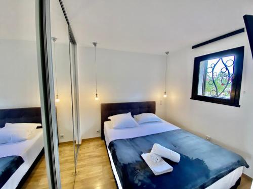 コゴランにあるLa terrasse tropézienneのベッドルーム1室(ベッド2台、窓付)