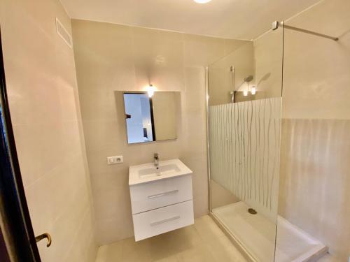 une salle de bain blanche avec un lavabo et une douche dans l'établissement La terrasse tropézienne, à Cogolin