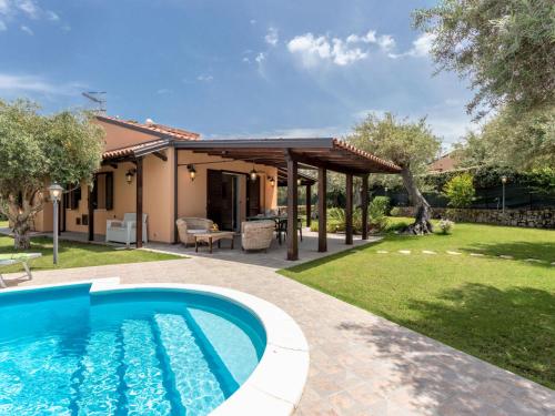 un patio trasero con piscina y pérgola en Villa Jancaliva by Interhome, en Lascari