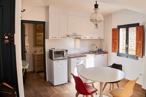 une cuisine avec une table blanche et une table et des chaises dans l'établissement Vista al Castillo de Mora de Rubielos VUTE-22-036, à Mora de Rubielos