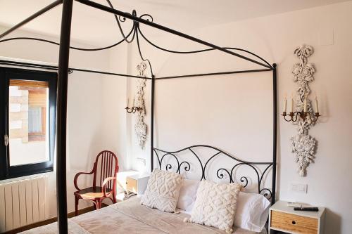 Vista al Castillo de Mora de Rubielos VUTE-22-036 في مورا دي روبيلوس: غرفة نوم مع سرير مظلة سوداء مع وسائد بيضاء