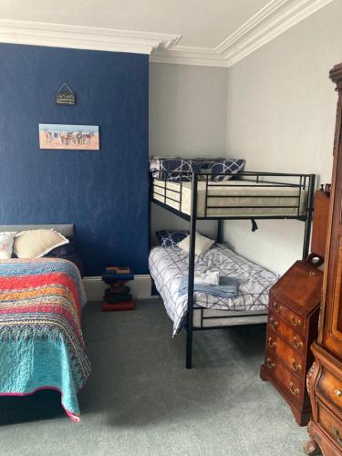 a bedroom with two bunk beds and a blue wall at Greyfriars Guest House in Bridlington
