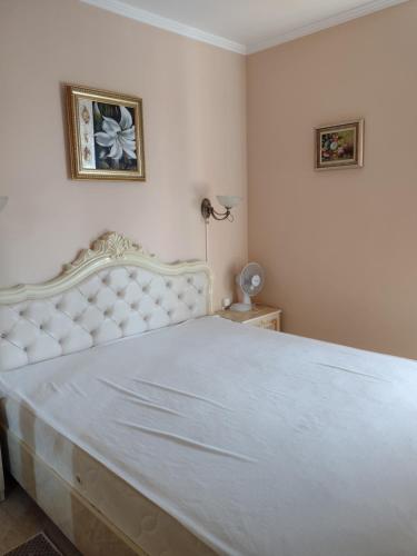 Un dormitorio con una gran cama blanca en una habitación. en Messembria Resort, en Sunny Beach