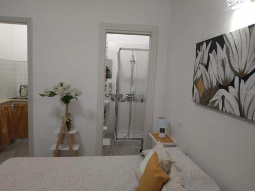 uma casa de banho com chuveiro e uma cama num quarto em B&B HOUSE BEN em Punta Prosciutto