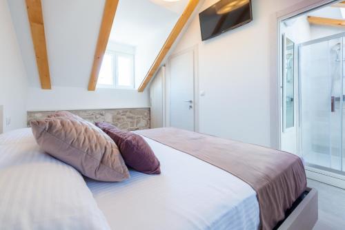 a bedroom with a bed with pillows and a window at Villa Luigi with a pool in Cavtat