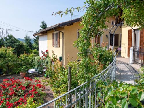 ein Haus mit einem Zaun und Blumen davor in der Unterkunft Apartment Ortondo B&B-3 by Interhome in Cortiglione