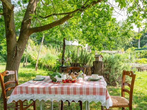 einen Tisch mit einem Teller Essen unter einem Baum in der Unterkunft Apartment Ortondo B&B-3 by Interhome in Cortiglione