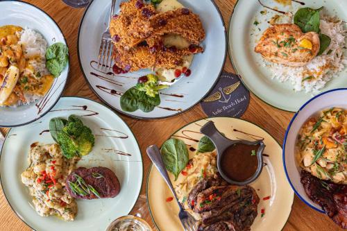 a table topped with plates of food on plates at Airlie Beach Hotel in Airlie Beach