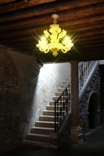 una lámpara de araña colgando del techo con una escalera en Casa Renata, en Venecia