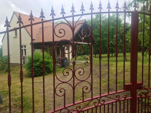 a iron fence with a house in the background at Maison de caractère à Mouterre-Silly avec grand jardin in Mouterre-Silly