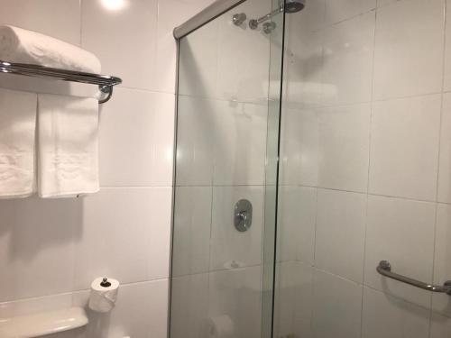 a shower with a glass door in a bathroom at Flat em Gramado in Gramado