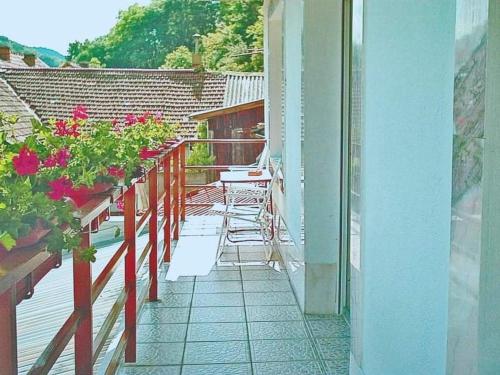 un balcone con sedie e fiori su una casa di Pensiunea Ca La Mama Acasa a Reşiţa
