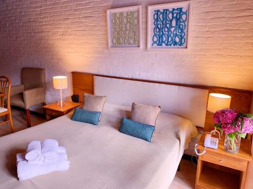 a bedroom with a large white bed with two pillows at Cariló Paradise Apart Hotel & Spa in Carilo