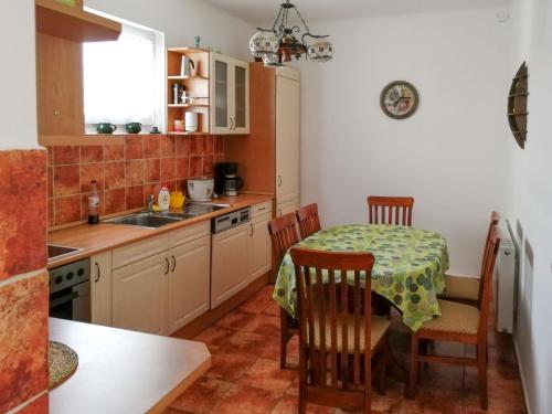 uma cozinha com uma mesa e cadeiras e um lavatório em Holiday Home Dekany - FOD151 by Interhome em Balatonfenyves