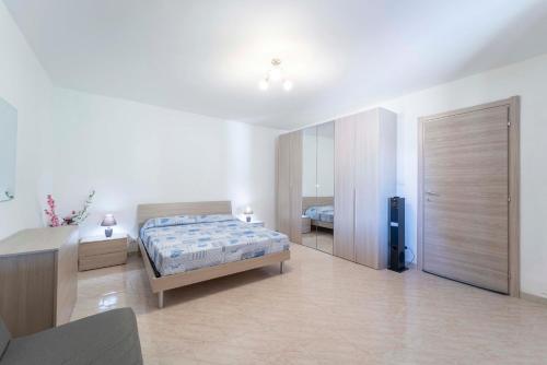 1 dormitorio con cama, escritorio y puerta en Open space accommodation, en Alghero