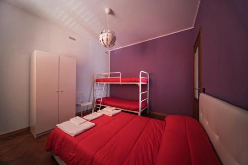 a bedroom with a red bed with a red blanket at Affittacamere Città delle Scienze Grugliasco in Turin
