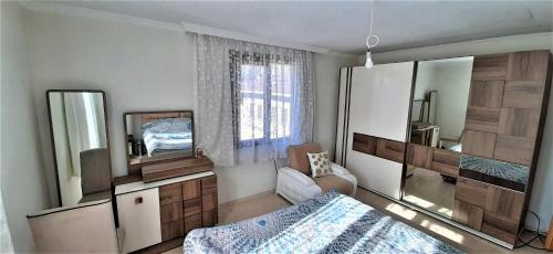 HayratにあるHayrat black sea apartsのベッドと大きな鏡のある寝室