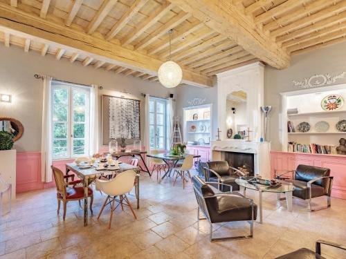 a living room with tables and chairs and a fireplace at Hôtel La Suite in Villeneuve-lès-Avignon
