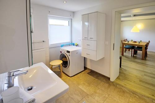 a bathroom with a sink and a washing machine at fewo1846 - Landliebe - idyllisch gelegene Wohnung mit 2 Schlafzimmern und Garten in Husby