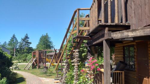 a playground with a wooden staircase next to a building at Lielās spāres in Pāvilosta