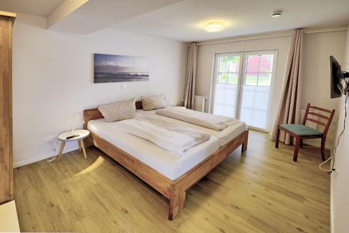 - une chambre avec un grand lit et une fenêtre dans l'établissement fewo1846 - Landliebe - idyllisch gelegene Wohnung mit 2 Schlafzimmern und Garten, à Husby