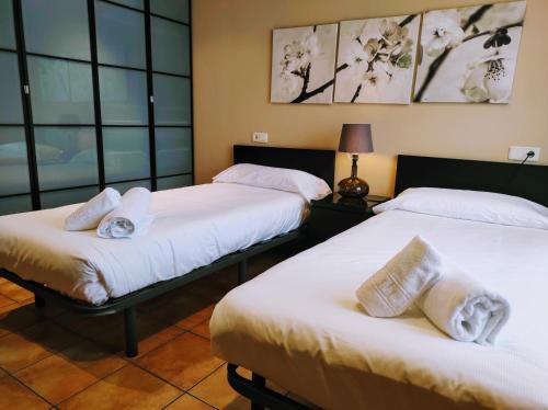 deux lits assis dans une pièce avec fenêtres dans l'établissement HOLIDAY HOMES Figueras AT, à Castropol